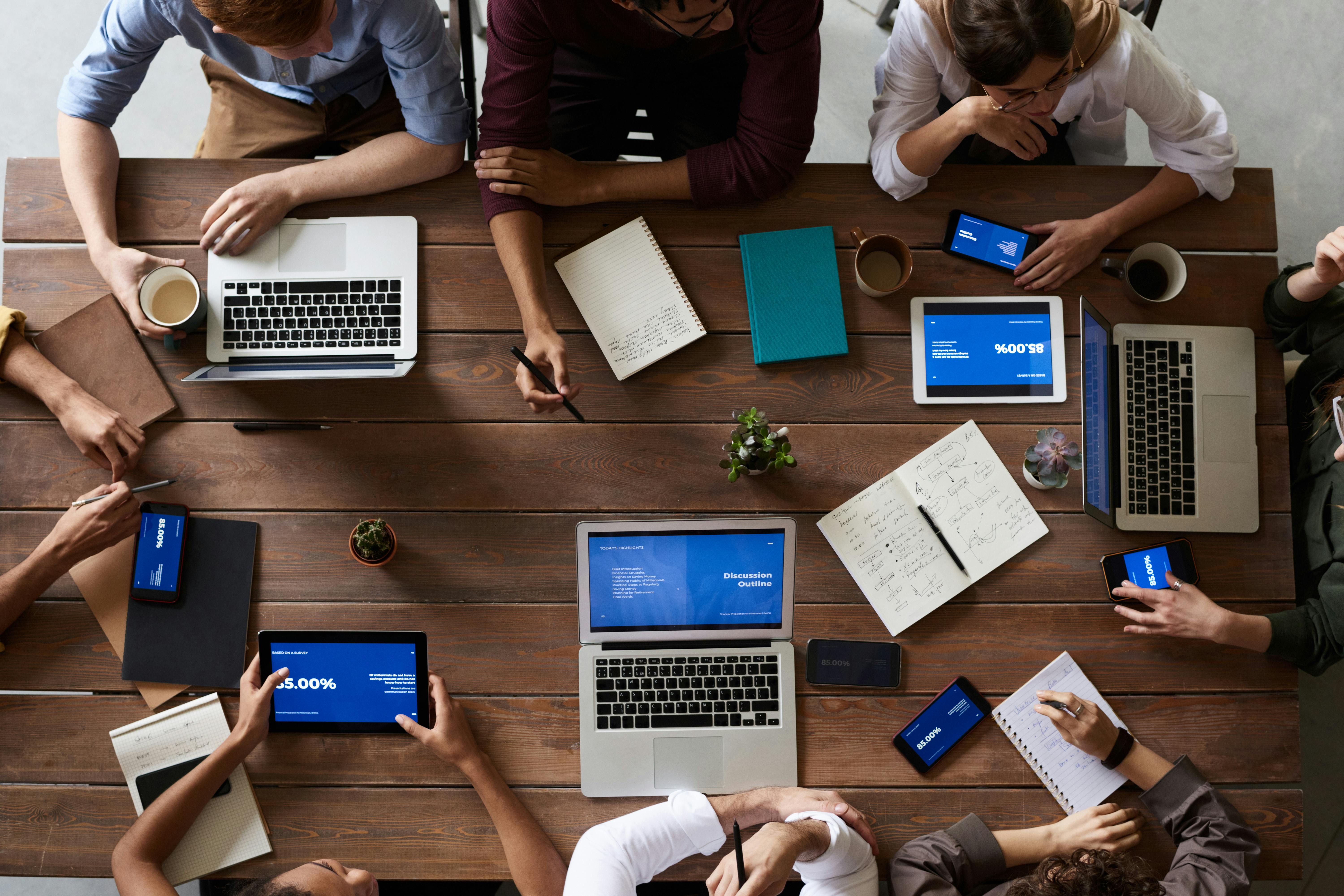 IT professionals collaborating in a modern office environment with digital displays showing cloud infrastructure diagrams